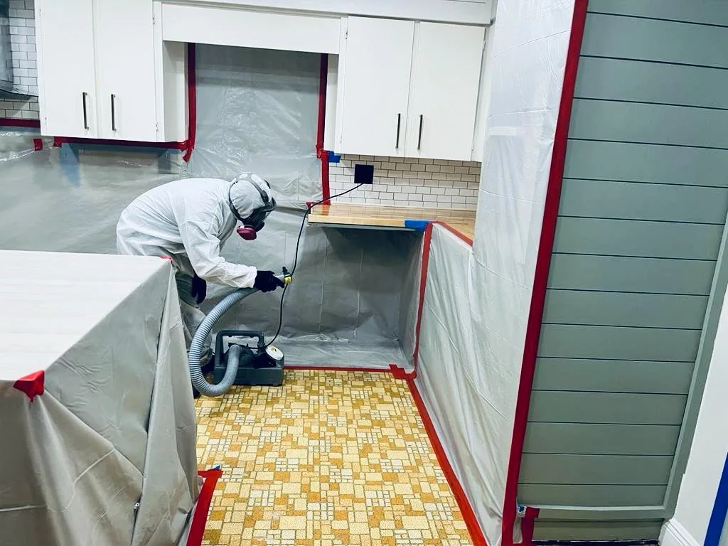 Mold remediation technician inspecting visible growth inside a protected work area